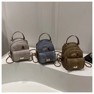 Détails de trois mini-sacs à dos en gris, bleu denim et marron olive avec motifs de chat