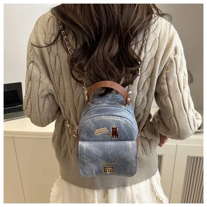 Mini sac à dos en jean bleu avec imprimé chat et bandoulière sur un mannequin