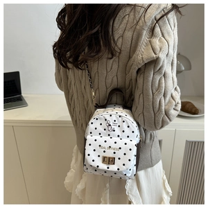Detailed view of polka dot mini backpack with cat illustration and metal chain strap