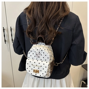 Détail du mini sac à dos à pois avec bandoulière chaîne et fermoir doré