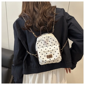 Vue détaillée du mini sac à dos à pois avec bandoulière chaîne sur un modèle