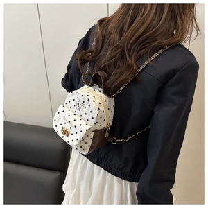 Détail d'un joli mini sac à dos à pois avec chaîne dorée et imprimé chaton heureux