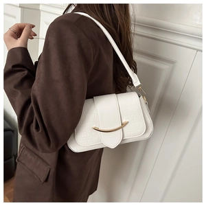 Vue détaillée du sac blanc avec motif crocodile et boucle métallique dorée courbée
