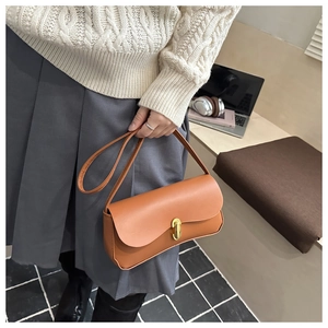 Detail of a brown matte leather shoulder bag with a gold metal twist lock closure