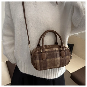 Detailed view of brown plaid wool crossbody bag with golden hardware and leather strap