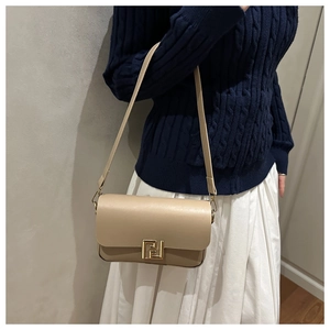 Close-up of beige leather crossbody bag with iconic gold F metal buckle detail