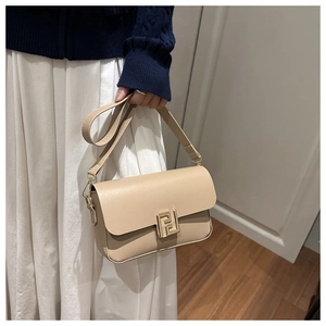Close-up of beige crossbody bag with gold metallic buckle and adjustable shoulder strap