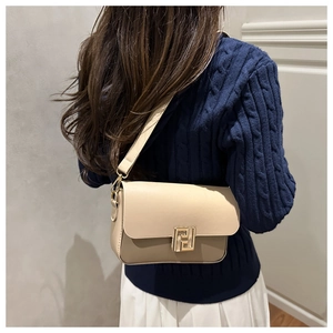 Detail of beige contrast crossbody bag with gold geometric lock on cable knit sweater
