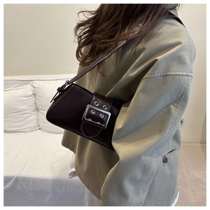 Detail of the oversized silver buckle and belt decoration on this brown leather shoulder bag