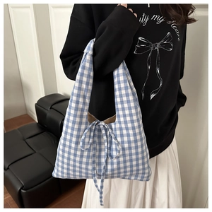 Detail of blue and white gingham canvas tote bag with a matching decorative bow