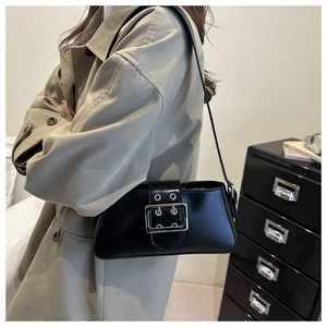 Détail du sac sous le bras en cuir noir avec boucle argentée et décoration de ceinture