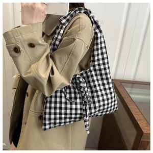 Detail shot of black and white gingham tote bag featuring side bow knot decoration