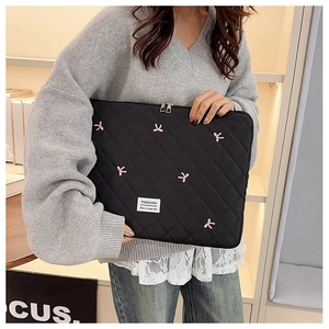 Dettaglio della custodia per laptop trapuntata nera con fiocco rosa e doppia zip