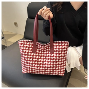Detail of red and white houndstooth knit tote bag with premium leather straps and stitching