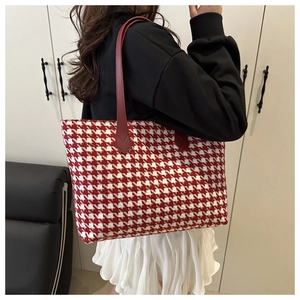 Detail of red and white houndstooth tote bag with premium leather shoulder straps