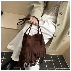 Vue détaillée du sac seau bohème en daim marron foncé avec de longues franges et cordon