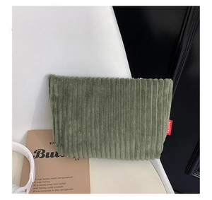 Detailed macro view of olive green corduroy cosmetic bag with red FASHION woven label