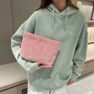 Detailed texture of pink corduroy pouch with a fashion label and secure zipper closure