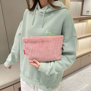 Close-up of pink corduroy envelope bag with Fashion tag and metal zipper detail