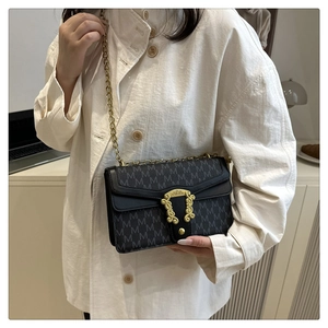 Macro view of checkered pattern shoulder bag with golden chain and metallic buckle