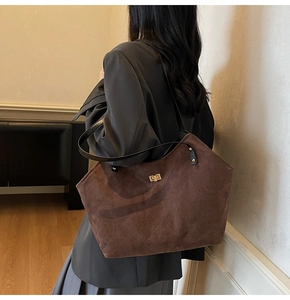 Detail of vintage quilted tote bag in dark brown suede with elegant gold twist lock