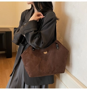 Détail du sac cabas en daim matelassé marron foncé avec fermoir rotatif en métal doré