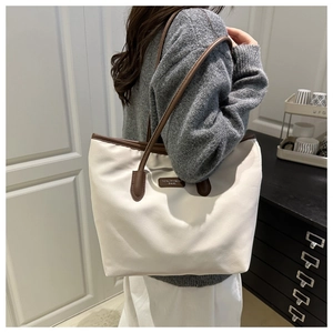 Macro detail of high-capacity tote bag with beige nylon texture and premium leather trim