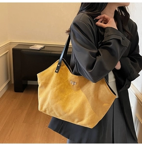Detail of vintage quilted tote bag in ginger yellow suede with silver twist lock