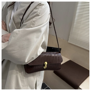 Détail du sac marron foncé effet crocodile avec fermoir en métal doré élégant