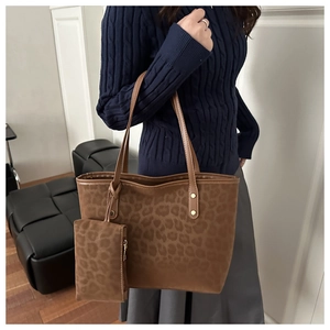 Gros plan sur le sac fourre-tout léopard avec anses en cuir et petit porte-monnaie assorti
