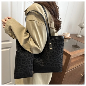 Détail du sac cabas léopard avec rivets dorés et pochette assortie sur mannequin