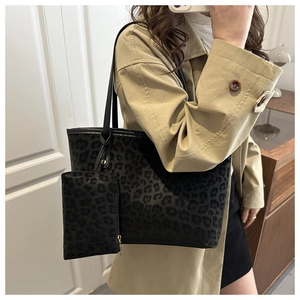 Gros plan d'un sac cabas imprimé léopard avec pochette assortie sur un mannequin