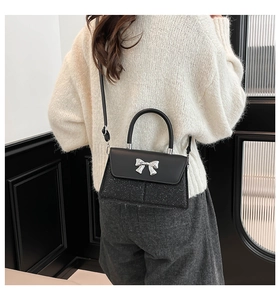 Detail of the black bow handbag showing the mixed texture materials and silver hardware