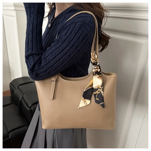 Khaki leather tote bag with decorative chain print silk scarf shown on model