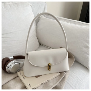 Close-up of white baguette bag with golden metal buckle on a minimalist cozy background