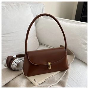 Close-up of a dark brown vintage baguette bag with a stylish golden metal buckle