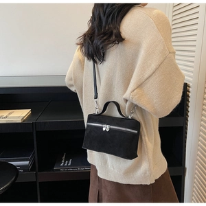 Detail of black matte crossbody bag featuring dual heart-shaped silver zipper pulls