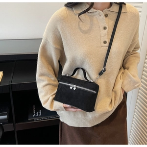 Détail du sac boîte noir mat avec fermetures éclair en cœur et poignée haute