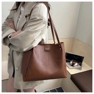 Detail of vintage brown leather tote bag with Fashion patch and spacious interior