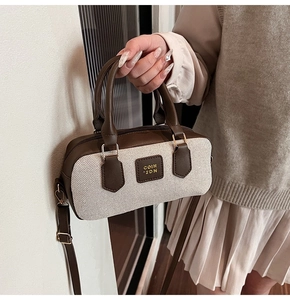 Detail of retro Boston bag with contrast leather stitching and gold logo lettering