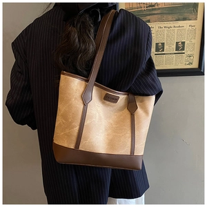 Dettaglio della borsa tote vintage in tela marrone chiaro con finiture in pelle scura