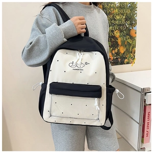 Detail view of the school backpack featuring cartoon dogs and a clear PVC front pocket