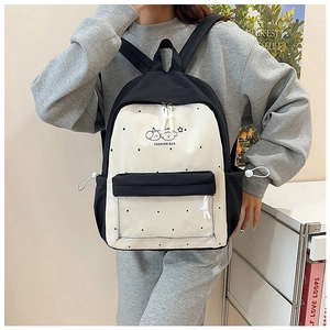 Detail of polka dot nylon backpack featuring transparent pocket and cute cartoon graphic