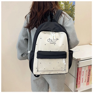 Detailed view of polka dot backpack with cartoon dog print and transparent zipper pocket