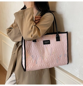 Detail of pink quilted tote bag with colorful wave embroidery and New York text label