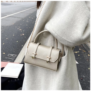 Détail du sac à main champagne avec bandoulière chaîne dorée et texture cuir grainé