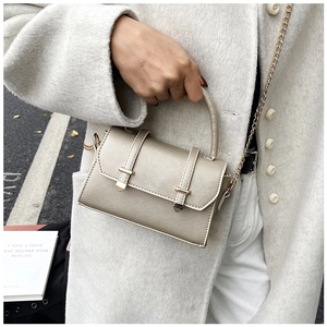 Mini champagne gold crossbody bag with chain strap styled on a tweed coat outfit