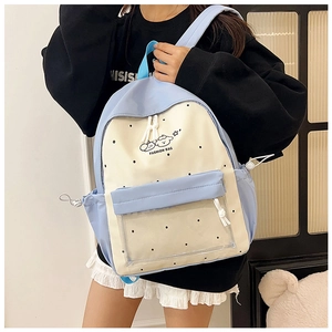 Detail of blue and beige backpack featuring cartoon graphics and transparent PVC pocket