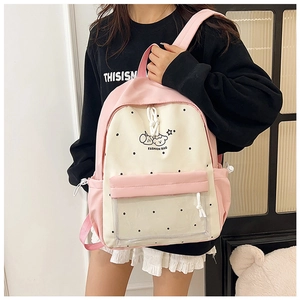 Detail of sweet pink and cream backpack with cute cartoon prints and polka dot patterns
