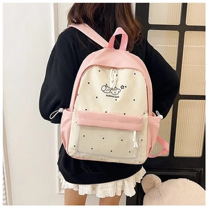 Rear view of a model wearing a pink polka dot backpack with a cute cartoon print